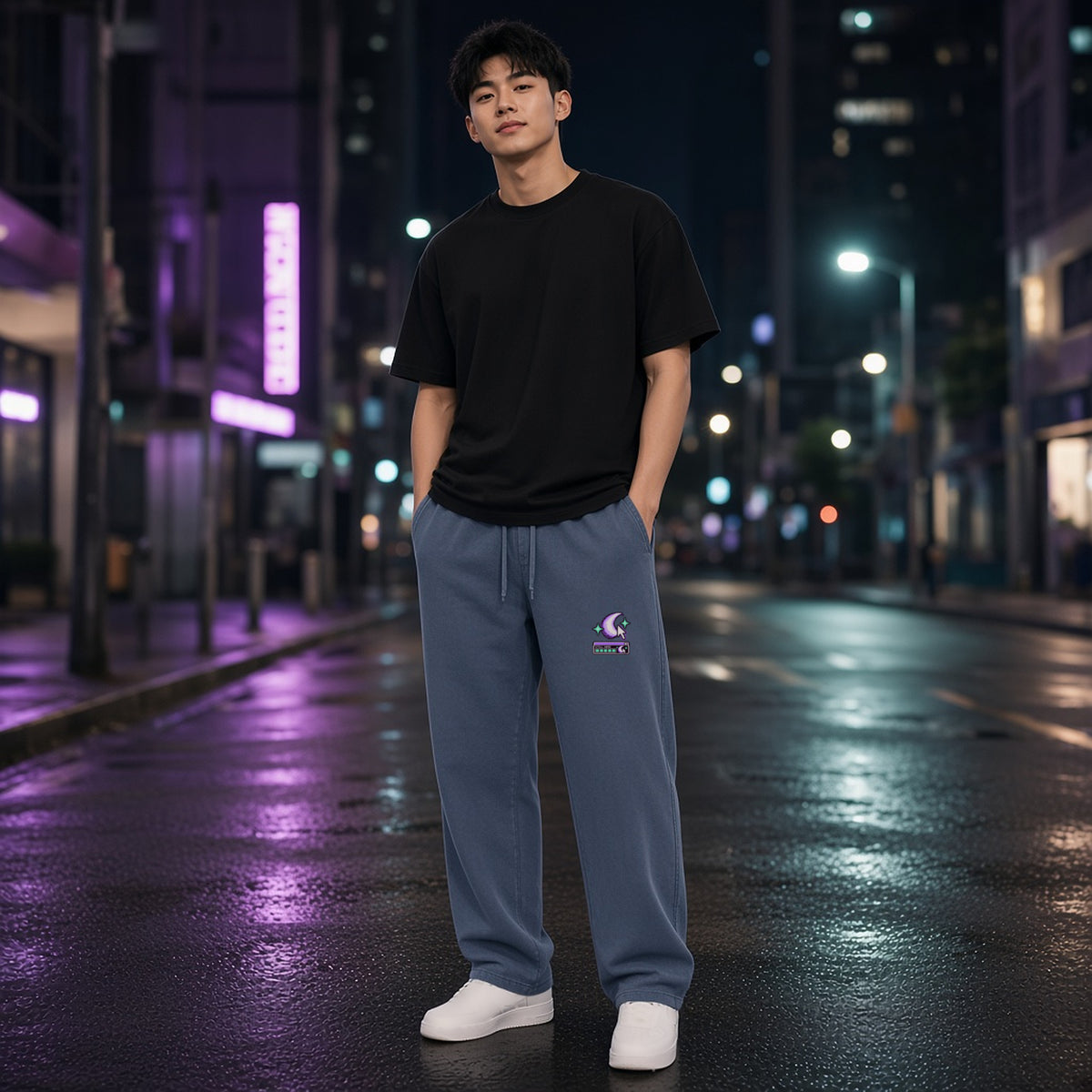 Front view of EvoCore Ghost Cache Navy Blue loose sweatpants worn on a neon-lit city street at night, crescent and cursor print on the left leg.