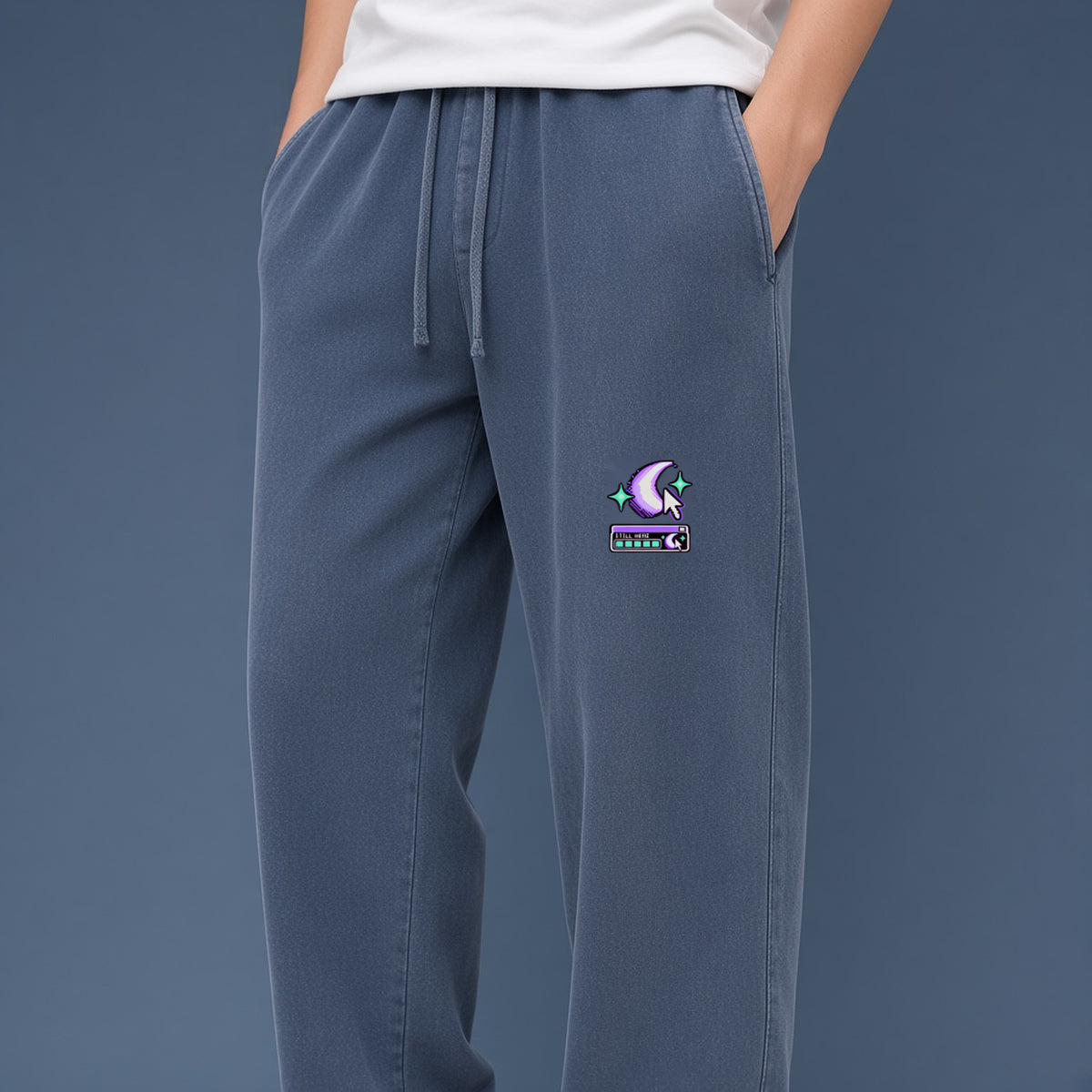 Close-up of the crescent, cursor and status-bar print on EvoCore Ghost Cache Navy Blue sweatpants against a slate studio backdrop.