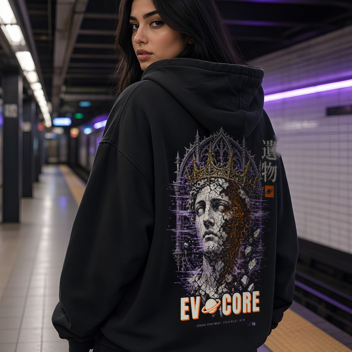 Over-the-shoulder look at the EvoCore Static Relic Hoodie on a subway platform, full-back crowned statue print