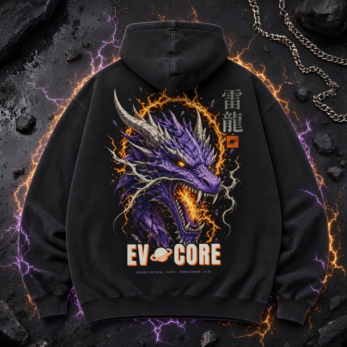 EvoCore Thunder Dragon Hoodie laid flat on dark asphalt with a silver chain, showing the full-back dragon and lightning print