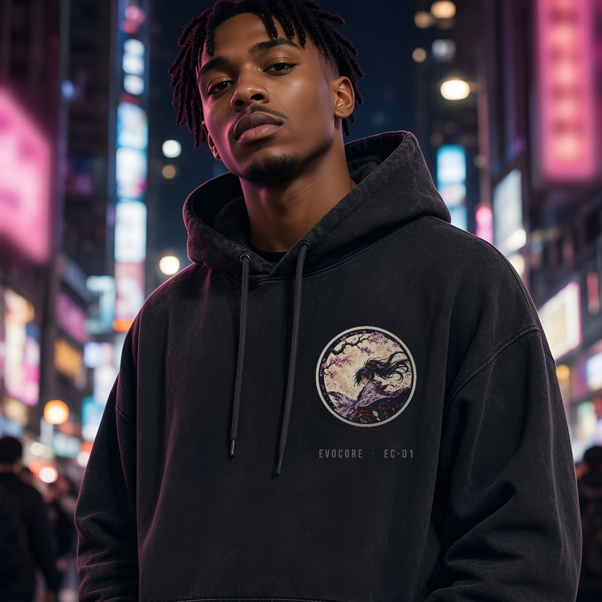 Front of the EvoCore Yozakura Hoodie in washed black with the round samurai-and-moon chest badge and EVOCORE · EC-01 text